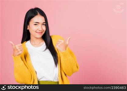  Portrait Asian beautiful young woman smile she standing made finger thumbs up, Ok sign to agree studio shot isolated on pink background, Thai female successful like finger gesture with copy space