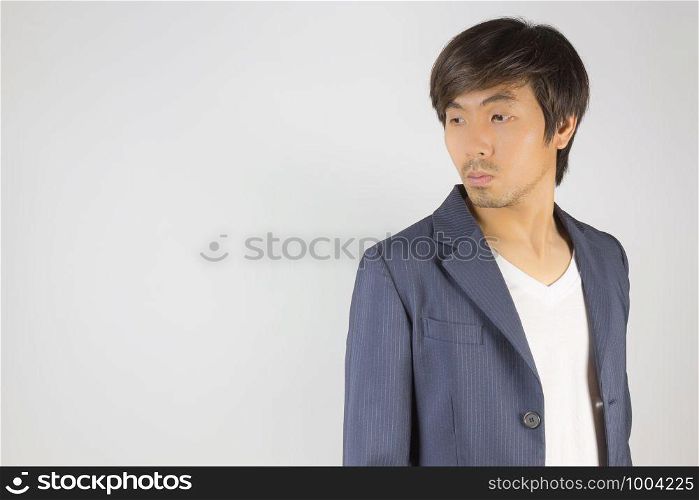Portrait Asian Casual Businessman in Navy Blue Suit with T-Shirt at Right Frame on Grey Background. Casual businessman wear suit fashion in semi formal style