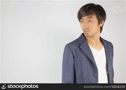 Portrait Asian Casual Businessman in Navy Blue Suit with T-Shirt at Right Frame on Grey Background. Casual businessman wear suit fashion in semi formal style