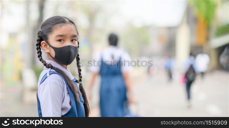 Portrait Asian children girl wear mask to protect PM 2.5 dust and air pollution. Portrait of Thai student wearing protection mask bad weather, concept of Corona virus quarantine,Covid-19