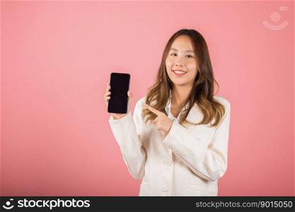 Portrait Asian happy beautiful young woman smile making finger pointing on screen smartphone in hand shopping online application looking to camera, studio shot isolated pink background with copy space