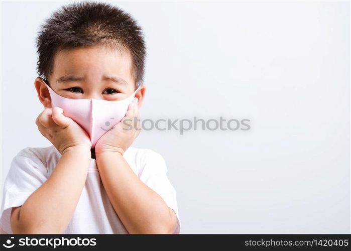 Portrait Asian little child boy wearing cloth face mask protective filter dust pm2.5, COVID-19 or coronavirus concept he looking to camera, studio shot isolated on white background with copy space