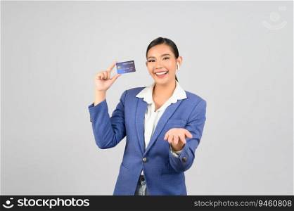 Portrait Asian young woman in officer uniform showing credit card in hand and open palm, copy space for insert advertising your product,  isolated on white background