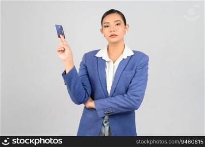Portrait Asian young woman in officer uniform standing posture talking with wireless earphone and showing credit card in hand,  isolated on white background