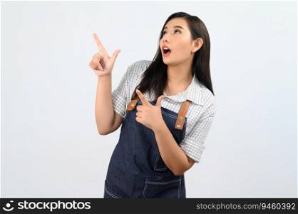 Portrait Asian young woman smile with happy in waitress uniform and apron, Cheerful girl standing with hand signal, point finger isolated on white background