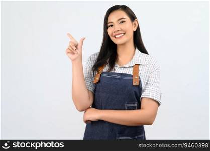 Portrait Asian young woman smile with happy in waitress uniform and apron, Cheerful girl standing with hand signal, point finger isolated on white background, copy space