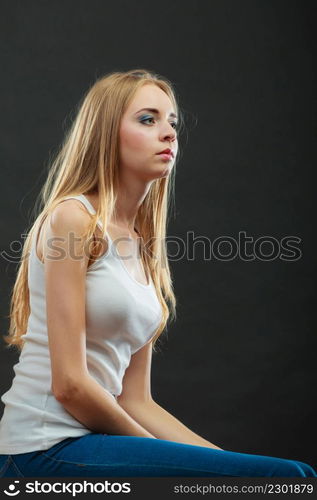 portrait attractive pensive woman, blonde long hair girl on black