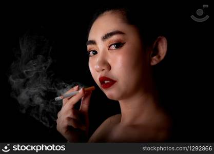 Portrait beautiful asea women do not wear clothes smoking look at the camera on the black background, Image of cigarette smoke spread in lady hand