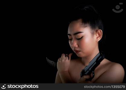 Portrait beautiful Asia woman one hand holding a gun and karambit knife at the black background, Young sexy girl long hair with a handgun, Pretty women stand with a pistol