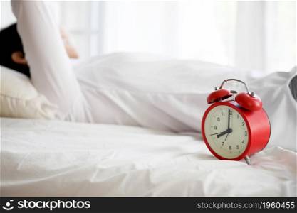 Portrait beautiful asian girl sitting with clock at white bedroom