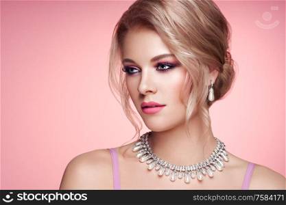 Portrait Beautiful Blonde Woman with Jewelry. Elegant Hairstyle. Beauty and Fashion Accessories. Perfect Make-Up. Pink Background