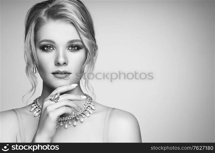Portrait Beautiful Blonde Woman with Jewelry. Model Girl with Pearl Manicure on Nails. Elegant Hairstyle. Precious Stones and Silver. Beauty and Fashion Accessories. Perfect Make-Up. Black and White photo
