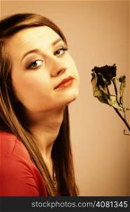 Portrait beautiful fashion woman teen girl in red gown with dry rose. Photo in old color image style.