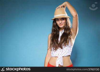 Portrait beautiful girl long hair in summer clothes and hat . Studio shot on blue background