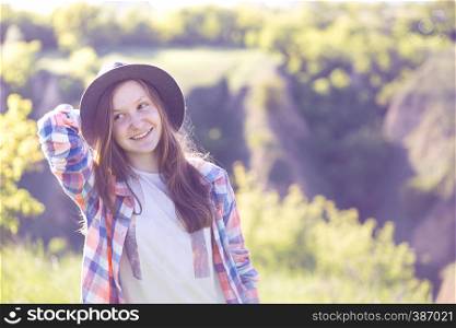 Portrait beautiful smiling teen girl in a hat on the nature