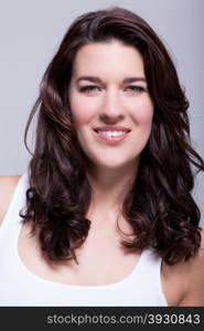 Portrait beautiful woman with dark hair smiling in the camera. Portrait beautiful woman with dark hair smiling in the camera on grey background