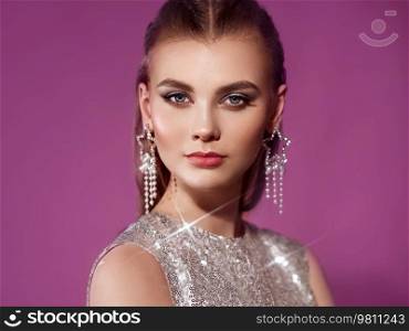 Portrait beautiful woman with jewelry. Beauty fashion. Eyelashes. Cosmetic eyeshadow. Care and beauty hair products. Model in a silver dress