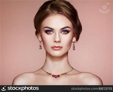 Portrait Beautiful Woman with Jewelry. Fashion Makeup and Cosmetics. Elegant Hairstyle. Violet Make-up Arrows. Beauty and Accessories