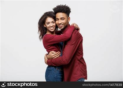Portrait beautiful young African couple standing close to each other and smiling at camera while isolated on white.. Portrait beautiful young African couple standing close to each other and smiling at camera while isolated on white