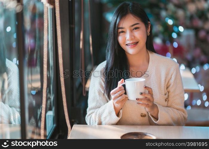 Portrait beautiful young asian woman girl wearing warm clothes enjoys drinking holding of positive the having cup of coffee,milk or chocolate at house home in the living room inside or cafe