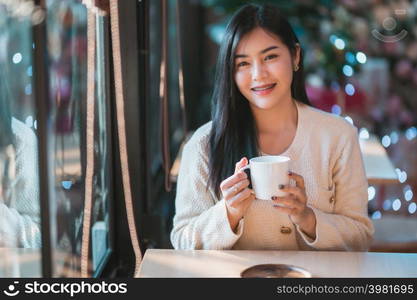 Portrait beautiful young asian woman girl wearing warm clothes enjoys drinking holding of positive the having cup of coffee,milk or chocolate at house home in the living room inside or cafe