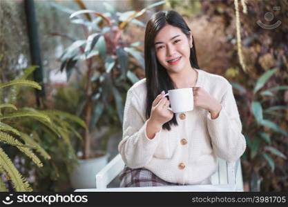Portrait beautiful young asian woman girl wearing warm clothes enjoys drinking holding of positive the having cup of coffee,milk or chocolate at house home in the living room inside or cafe