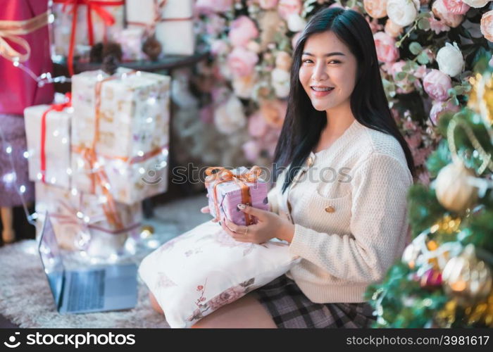 Portrait beautiful young asian woman girl wearing warm clothes exchanging gifts and Give a present at house home in the living room inside or cafe,During Christmas x-mas and New Year holidays.