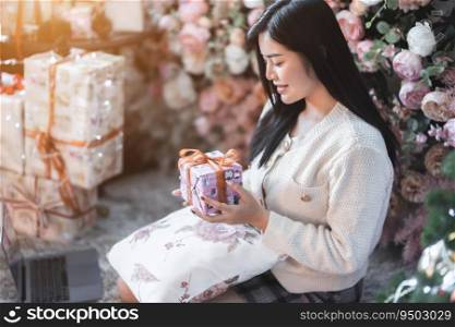 Portrait beautiful young asian woman girl wearing warm clothes exchanging gifts and Give a present at house home in the living room inside or cafe,During Christmas x-mas and New Year holidays.