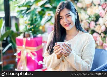 Portrait beautiful young asian woman holding of positive the having cup of coffee,milk or chocolate at home in the living room indoors Decoration During Christmas x-mas and New Year holidays.