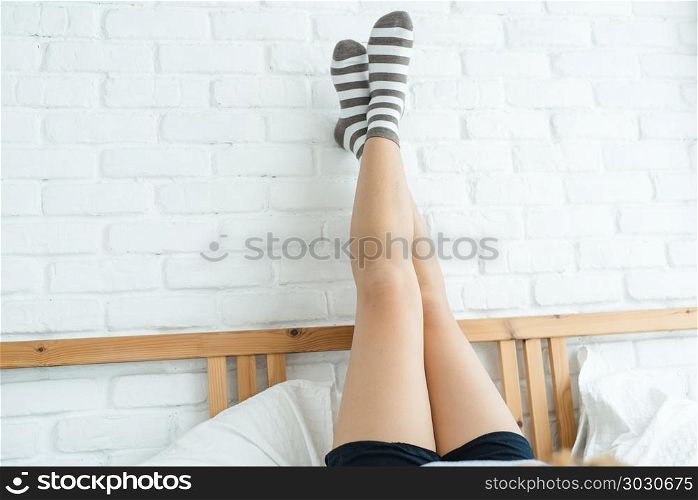Portrait beautiful young Asian woman on bed at home in the morni. Portrait beautiful young Asian woman on bed at home in the morning. Cheerful Asian woman wearing a comfortable sweater and smiling on her bed. Relaxing room. lifestyle asia woman at home concept.