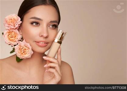 Portrait beautiful young woman with clean fresh skin. Model with foundation makeup bottle. Beautiful young woman with a rose flower