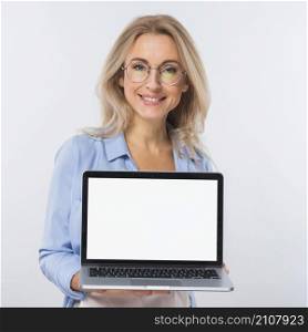 portrait blonde young woman holding open laptop with blank screen against white backdrop