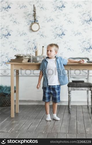 portrait boy standing near table living room
