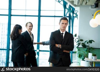 Portrait businessman with teammates discussing in the background.