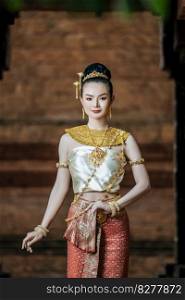 Portrait Charming Thai woman in Beautiful traditional dress costume, woman wearing typical thai dress standing in archaeological site or thai temple background, identity culture of thailand