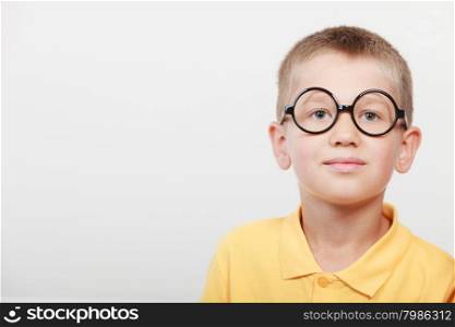 Portrait close up of cute serious kid little boy nerd in glasses.