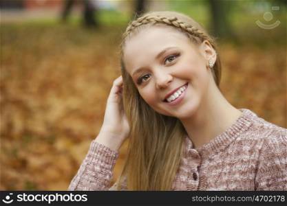 Portrait close up of young beautiful blonde women, on golden background autumn nature
