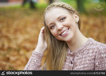 Portrait close up of young beautiful blonde women, on golden background autumn nature