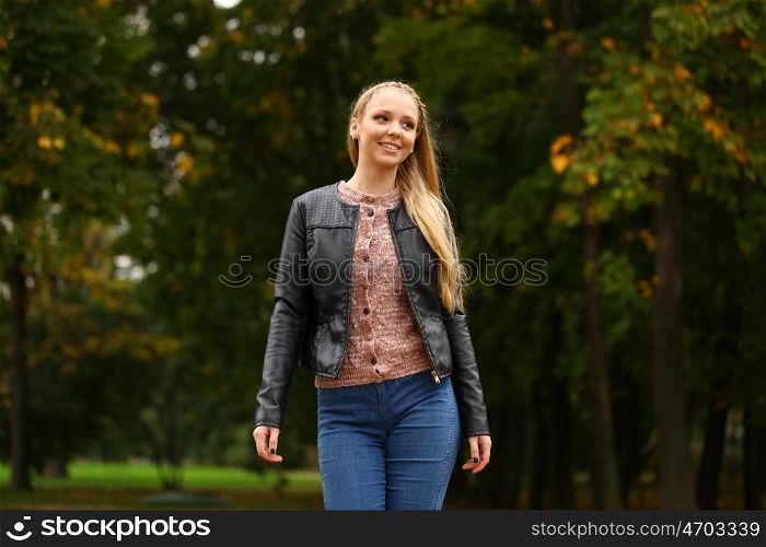 Portrait close up of young beautiful blonde women walking, on background autumn park
