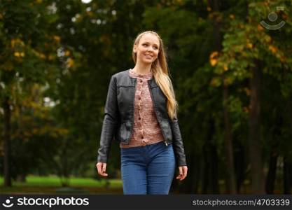 Portrait close up of young beautiful blonde women walking, on background autumn park