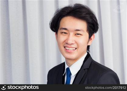 Portrait closeup of happy Asian young handsome manager professional business man laughing confident mature standing in suit smiling looking to camera with copy space