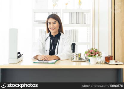 Portrait confident female doctor medical professional sitting in examination room in hospital clinic. Positive face expression