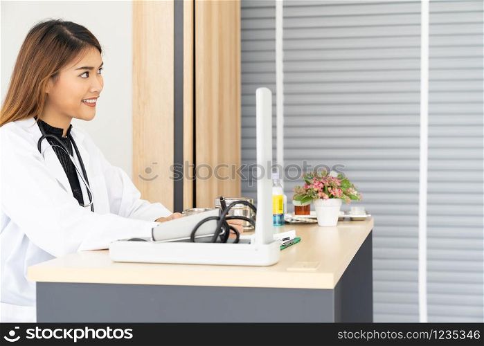 Portrait confident female doctor medical professional sitting in examination room in hospital clinic. Positive face expression