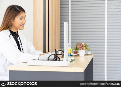 Portrait confident female doctor medical professional sitting in examination room in hospital clinic. Positive face expression