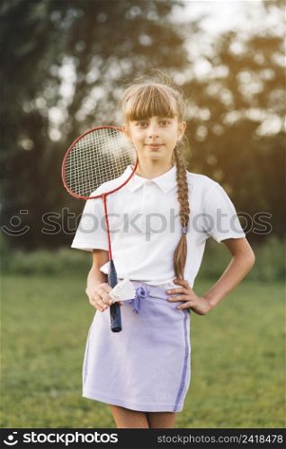 portrait confident girl standing with badminton shuttlecock