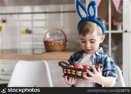 portrait cute little boy holding painted eggs