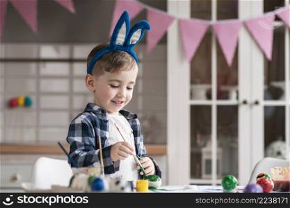 portrait cute little boy painting eggs easter