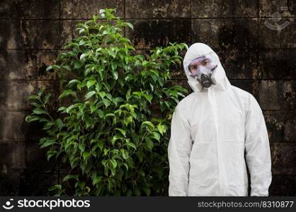 Portrait Disinfection specialist man in PPE suit, gloves, mask and face shield performing public decontamination, standing with feel tired during disinfectant to remove covid-19