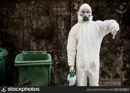 Portrait Disinfection specialist man in PPE suit, gloves, mask and face shield performing public decontamination, standing with thump down and holding bottle for spray disinfectant to remove covid-19  