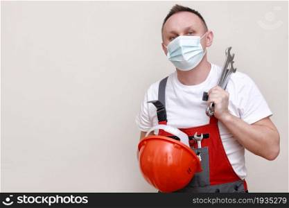 portrait engineer worker or mechanic wearing helmet and face mask for protect virus covid 19 on white background, with holding wrench. labor day.. portrait engineer worker or mechanic wearing helmet and face mask for protect virus covid 19 on white background, with holding wrench. labor day